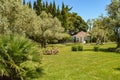 Picturesque view of the Mediterranean landscape with a beautiful lawn, a small farmhouse and olive and cypress trees Royalty Free Stock Photo