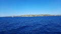 Picturesque view to blue sea and mountain island on horizon in mist. Calm water surface, background for traveling and Royalty Free Stock Photo