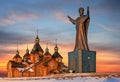 Picturesque view of the wooden Orthodox Church and the monument to St. Nicholas the Wonderworker.