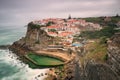 Picturesque village Azenhas do Mar. Holiday white houses on the edge of a cliff with a beach and swimming pool below. Landmark nea Royalty Free Stock Photo