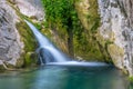 A picturesque waterfall in a cozy mountain lagoon. Royalty Free Stock Photo