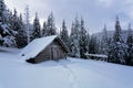 Picturesque winter landscape with huts, snowy mountains and forest.