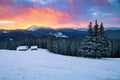 Picturesque winter landscape with huts, snowy mountains.