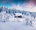 Picturesque winter sunrise in Carpathian village with snow cower