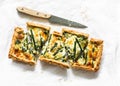 Pie with asparagus, mozzarella and spinach on a light background, top view. Delicious snack, tapas, appetizer