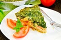 Pie celtic with spinach and tomatoes on table