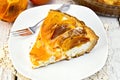 Pie with curd and persimmons with fork in plate on board Royalty Free Stock Photo