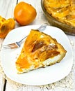 Pie with curd and persimmons in plate on silicone Royalty Free Stock Photo