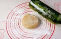 Pie dough with wine bottle used as a rolling pin on a baking mat Royalty Free Stock Photo