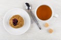 Pie with lingonberry, tea, sugar cubes, spoon on wooden table Royalty Free Stock Photo