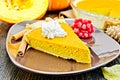Pie pumpkin in brown plate with cream on dark board Royalty Free Stock Photo