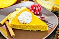 Pie pumpkin in plate with cream on dark board Royalty Free Stock Photo