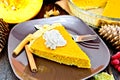 Pie pumpkin in plate with whipped cream on board Royalty Free Stock Photo