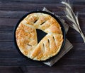 Pie with sesame on a sacking, ears of wheat. Dark wooden background Royalty Free Stock Photo