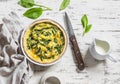 Pie with spinach, cheese and egg on a wooden background