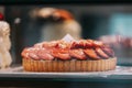 pie with strawberries, assortment baked pastry in bakery. Various Different Types Of Sweet Cakes In Pastry Shop Glass