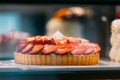 pie with strawberries, assortment baked pastry in bakery. Various Different Types Of Sweet Cakes In Pastry Shop Glass