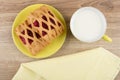 Pie in yellow saucer, cup of milk and napkin Royalty Free Stock Photo