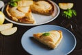 Piece of apple French pie on blue plate looks appetizing and surprisingly fresh. Thin slices of juicy apples and crispy puff Royalty Free Stock Photo