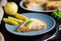 Piece of apple French pie on blue plate looks appetizing and surprisingly fresh. Thin slices of juicy apples and crispy puff Royalty Free Stock Photo