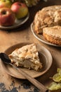 A piece of apple pie charlotte sprinkled with cinnamon on wooden background. Tea time with apple dessert, autumn moody Royalty Free Stock Photo