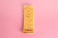 Piece of an apple pie on a pink background