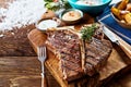 Piece of barbecued t-bone steak on wooden board Royalty Free Stock Photo