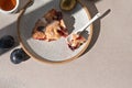 Piece of bitten plum pie on plate with dessertspoon, on beige table background. Delicious fruit bakery, cake with plum