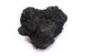 A piece of black coal on a light background Royalty Free Stock Photo