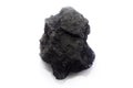 A piece of black coal on light background Royalty Free Stock Photo