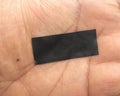 Piece of black electrical insulation tape on palm of hand Royalty Free Stock Photo