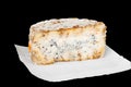 A piece of blue aged delicatessen Stilton cheese on a piece of white paper. Quality of agricultural products. Isolated on black