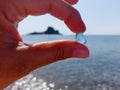 A piece of blue glass in two fingers