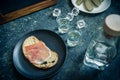 A piece of bread with slice of pork and shots of vodka on wooden background Royalty Free Stock Photo