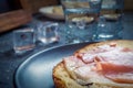 A piece of bread with slice of pork and shots of vodka on wooden background Royalty Free Stock Photo