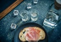 A piece of bread with slice of pork and shots of vodka on wooden background Royalty Free Stock Photo