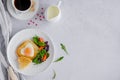 Piece of bread toast cut in shape of heart with egg on a white plate with arugula and cherry tomatoes. Royalty Free Stock Photo