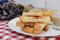 Piece of bread toast with dipping sauce on white plate.Thai Pandan mixed milk custard Custard & grilled bread.