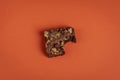 Piece of brownie bitten on an orange background. Minimalist style, above view Royalty Free Stock Photo