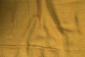 A piece of brownish-gold fabric with a textured surface and visible weave pattern.