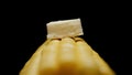 Piece of butter on sweetcorn cob on a black background. Close up. Royalty Free Stock Photo