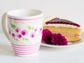 A piece of cake with beautiful mug and violet flower