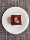 A piece of cake with a heart decor on a plate.