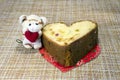 A piece of cake in the shape of a heart and a toy with a heart Royalty Free Stock Photo
