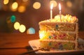 a piece of cake on top of lighted birthday cake birthday cake