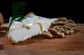 A piece of camembert cheese and walnut lie on a wooden board. Camembert cheese with white noble mold Royalty Free Stock Photo