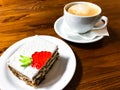 Piece of carrot cake and cappuccino on wooden table Royalty Free Stock Photo