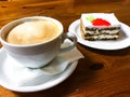 Piece of carrot cake and cappuccino on wooden table Royalty Free Stock Photo