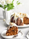 A piece of carrot cake decorated with icing, walnuts and Easter decor on a dessert plate on a light background Royalty Free Stock Photo