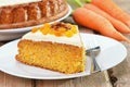 Piece of carrot cake with icing decorated dried apricots and walnut